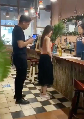 Girl looking awkward while paying at a drink stand