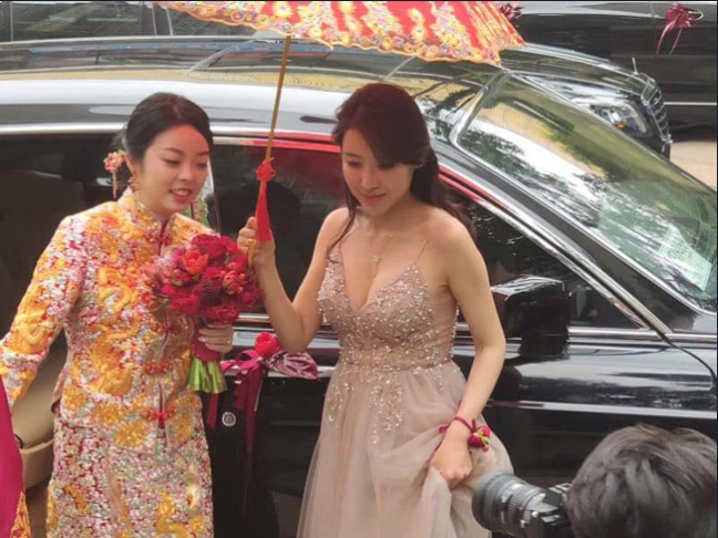 This bridesmaid wears a spaghetti strap dress, boldly showing off her chest.