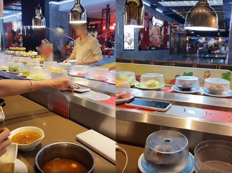 The guy casually places his phone on the hotpot conveyor belt