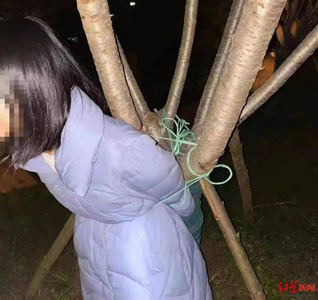 Girl tied to a tree in the forest