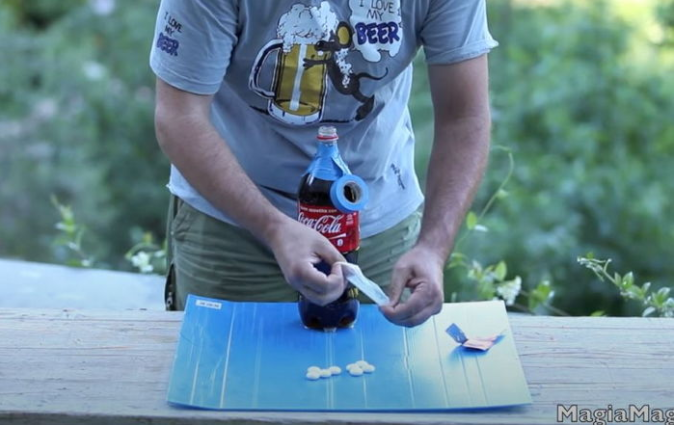 YouTuber Tests Mentos and Coke Reaction Inside a Condom 1 Scene showing Milleaccendini with Mentos, a condom, and a bottle of Coca-Cola