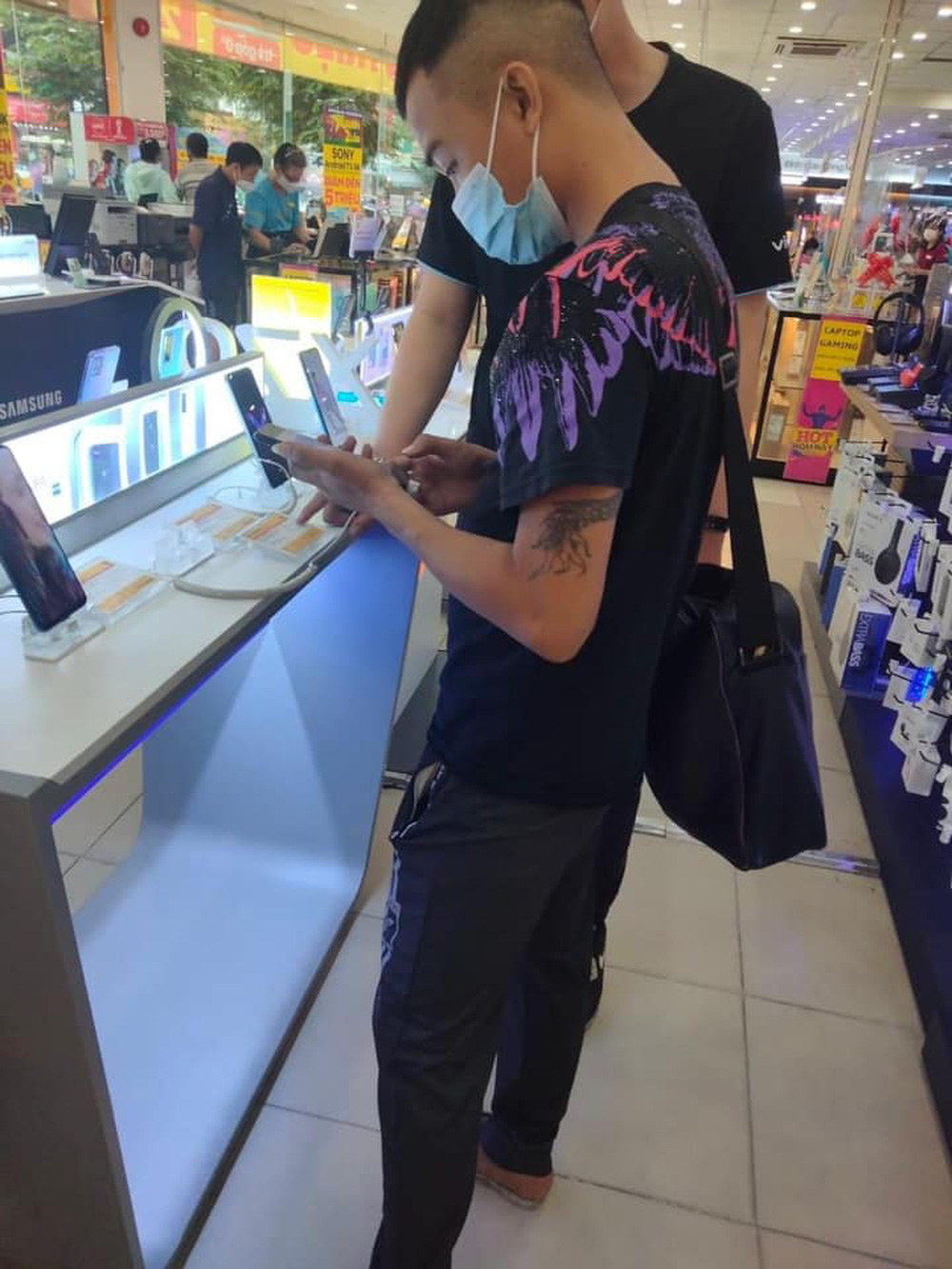 Couple carrying dozens of stacks of 500 dong bills to buy a phone