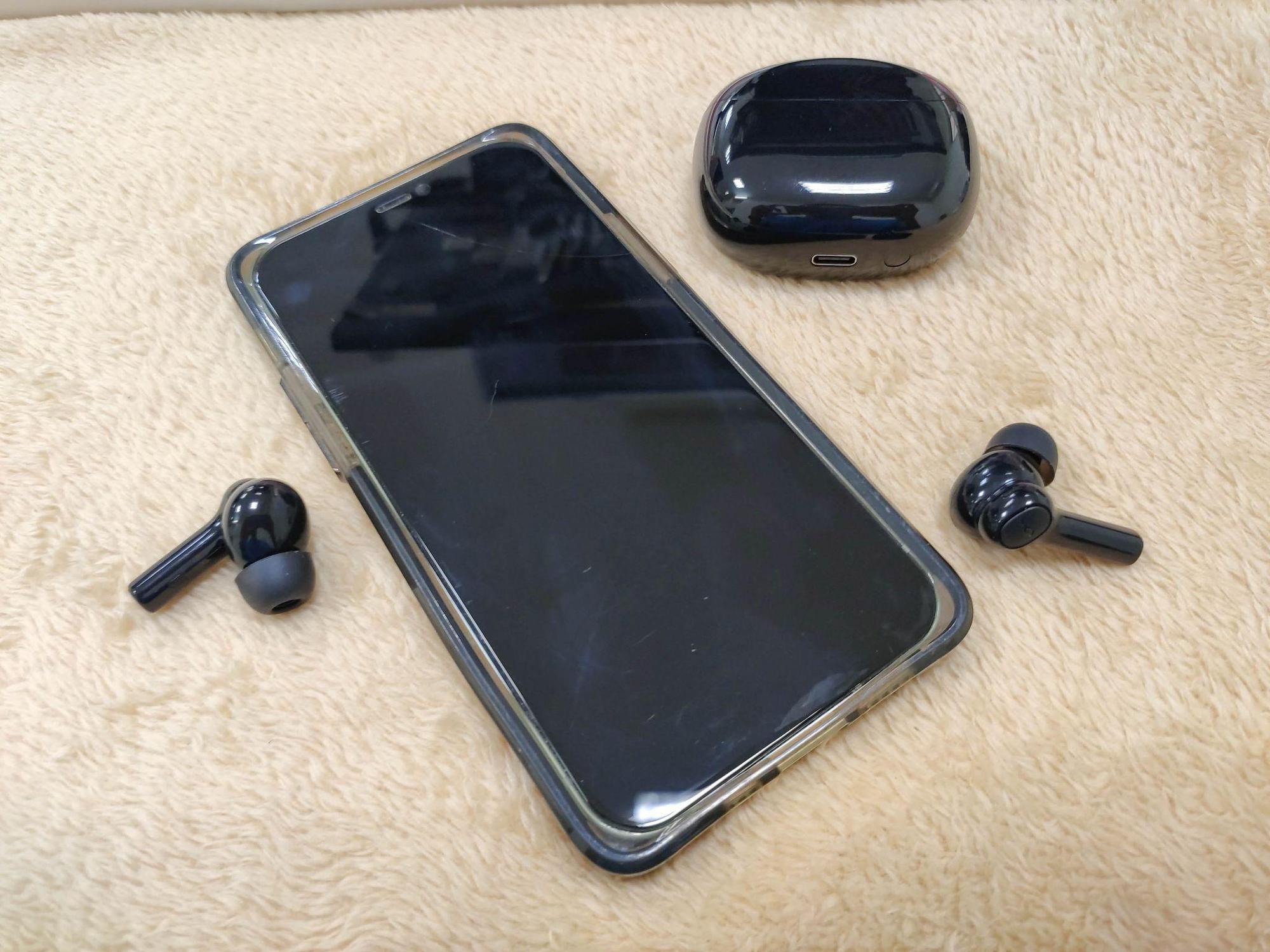 Soundcore R100 earbuds in hand