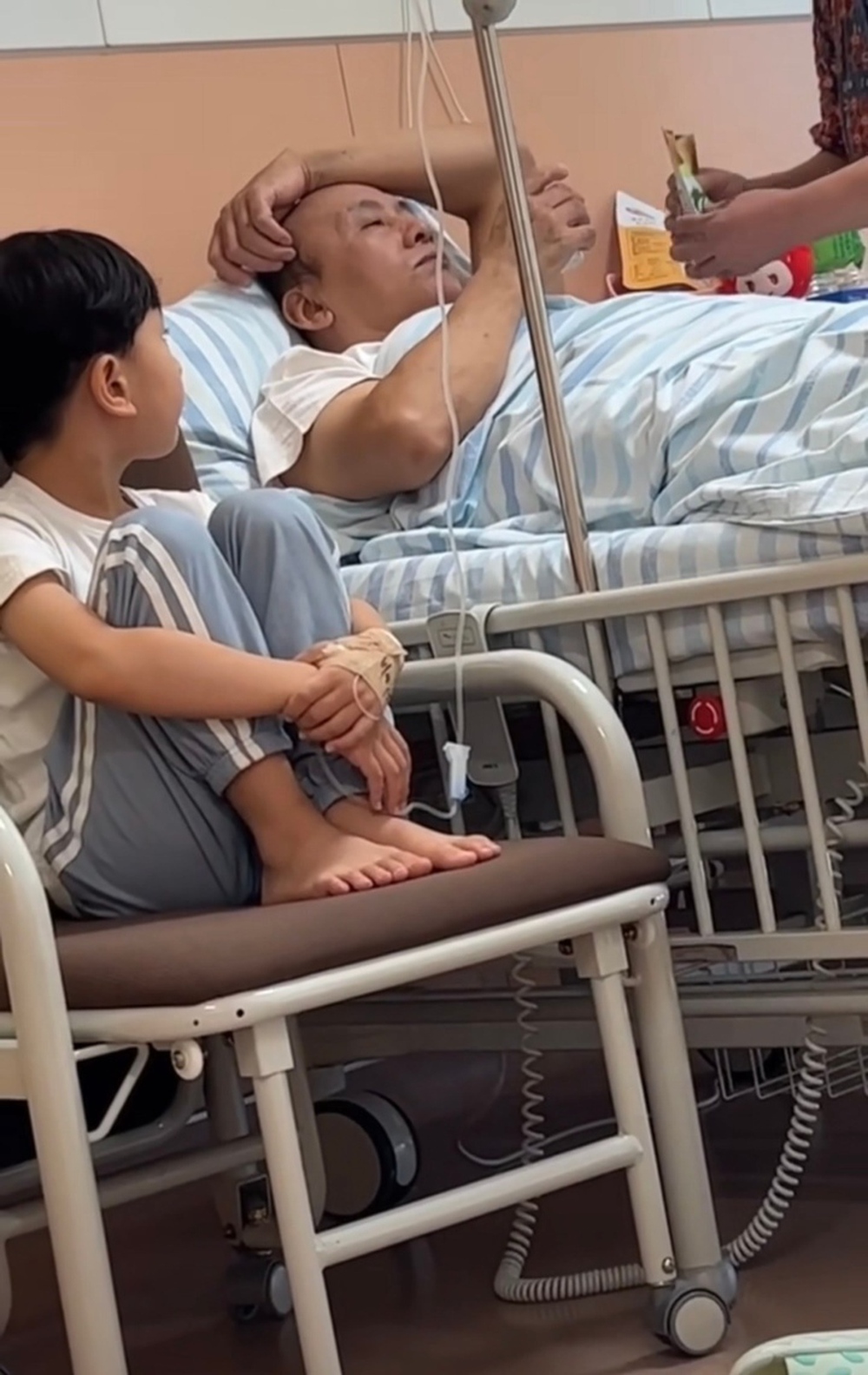 Kid Patient Looks Totally Done When Grandparents Visit Hospital 3 The kid patient keeps glancing at the bed where his grandfather is being fed by his grandmother.