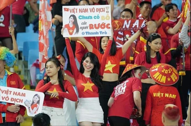 Angolan Vlogger Sparks Debate Posing with Vietnamese Hot Girl 5 Thanh Trà holding a 'husband recruitment' sign at Mỹ Đình Stadium