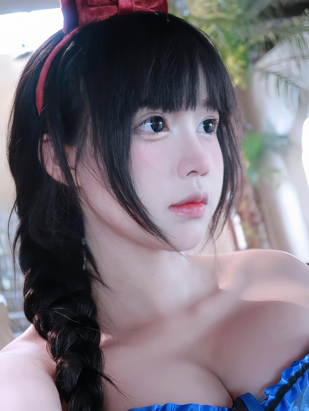Snow White cosplay with long curly hair and red bow