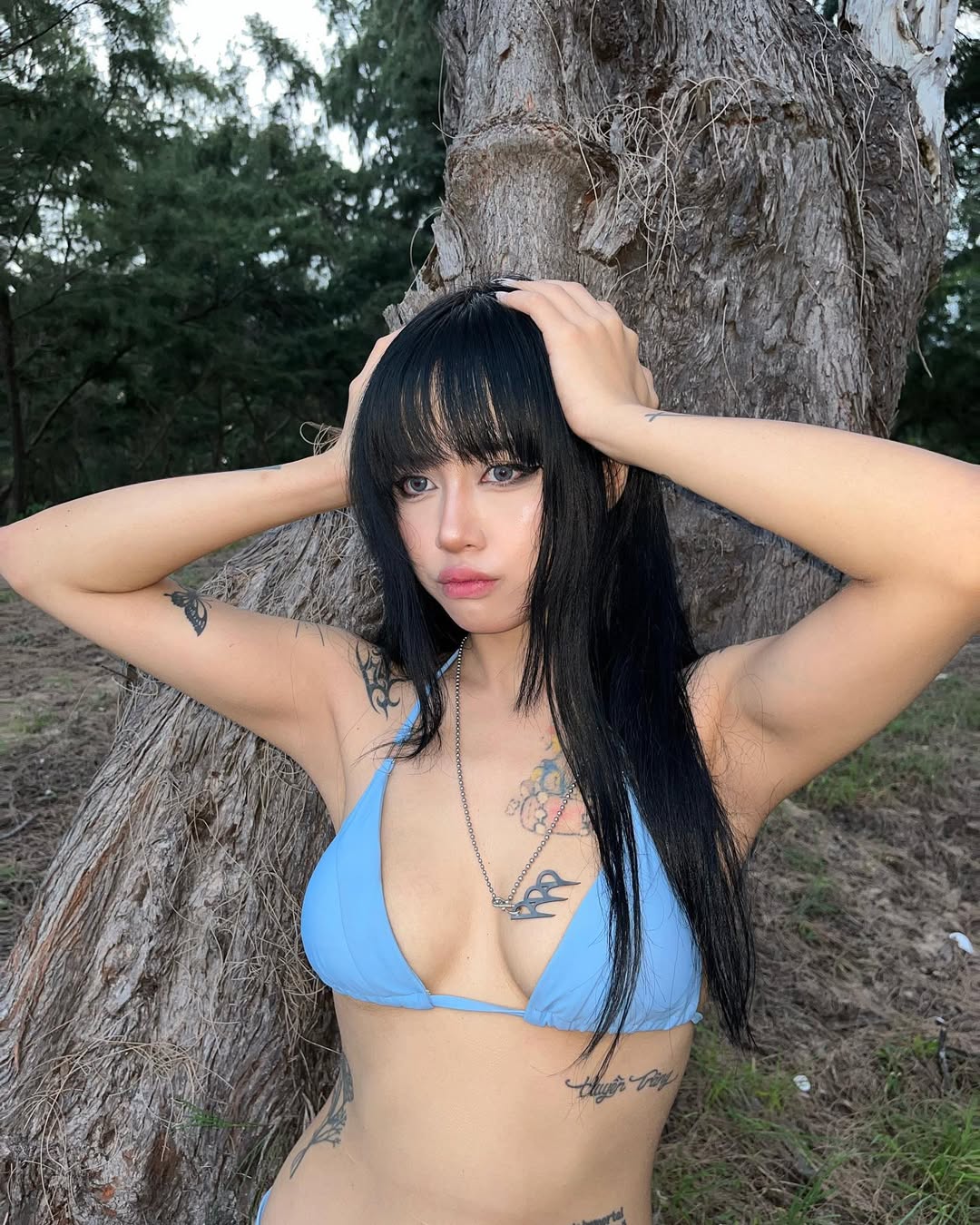 Quitmell in an earthy brown string bikini by the waterfall