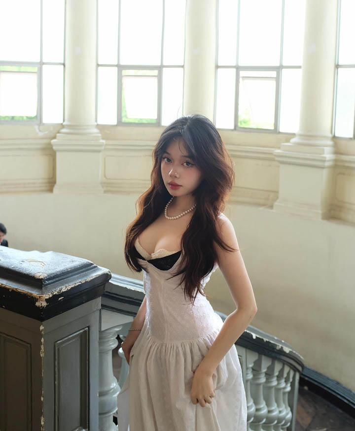 Quỳnh Anh wearing a delicate white dress with lace details
