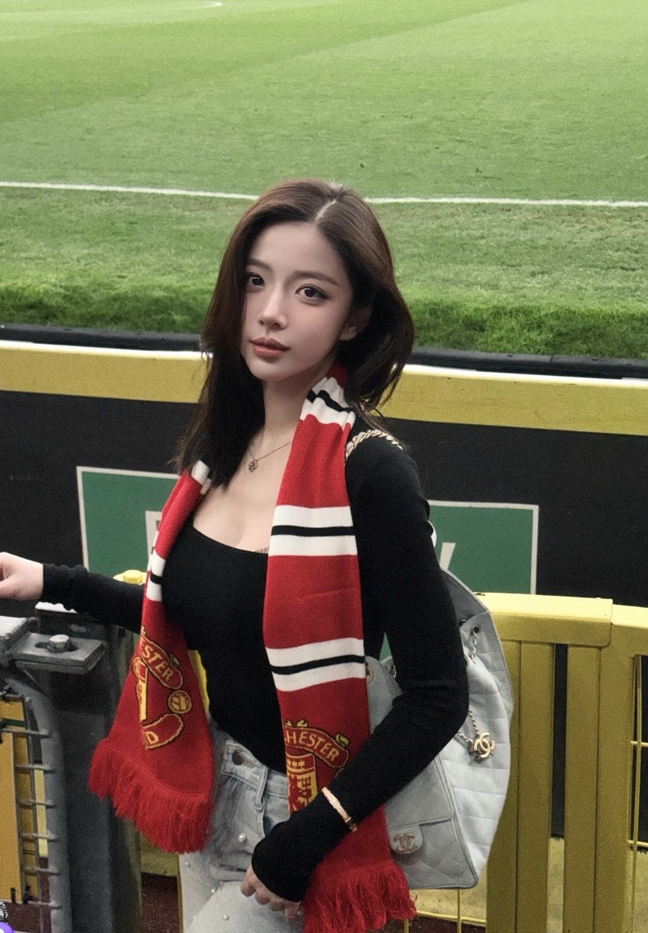 Hằng Phan wearing a Manchester United scarf at Old Trafford