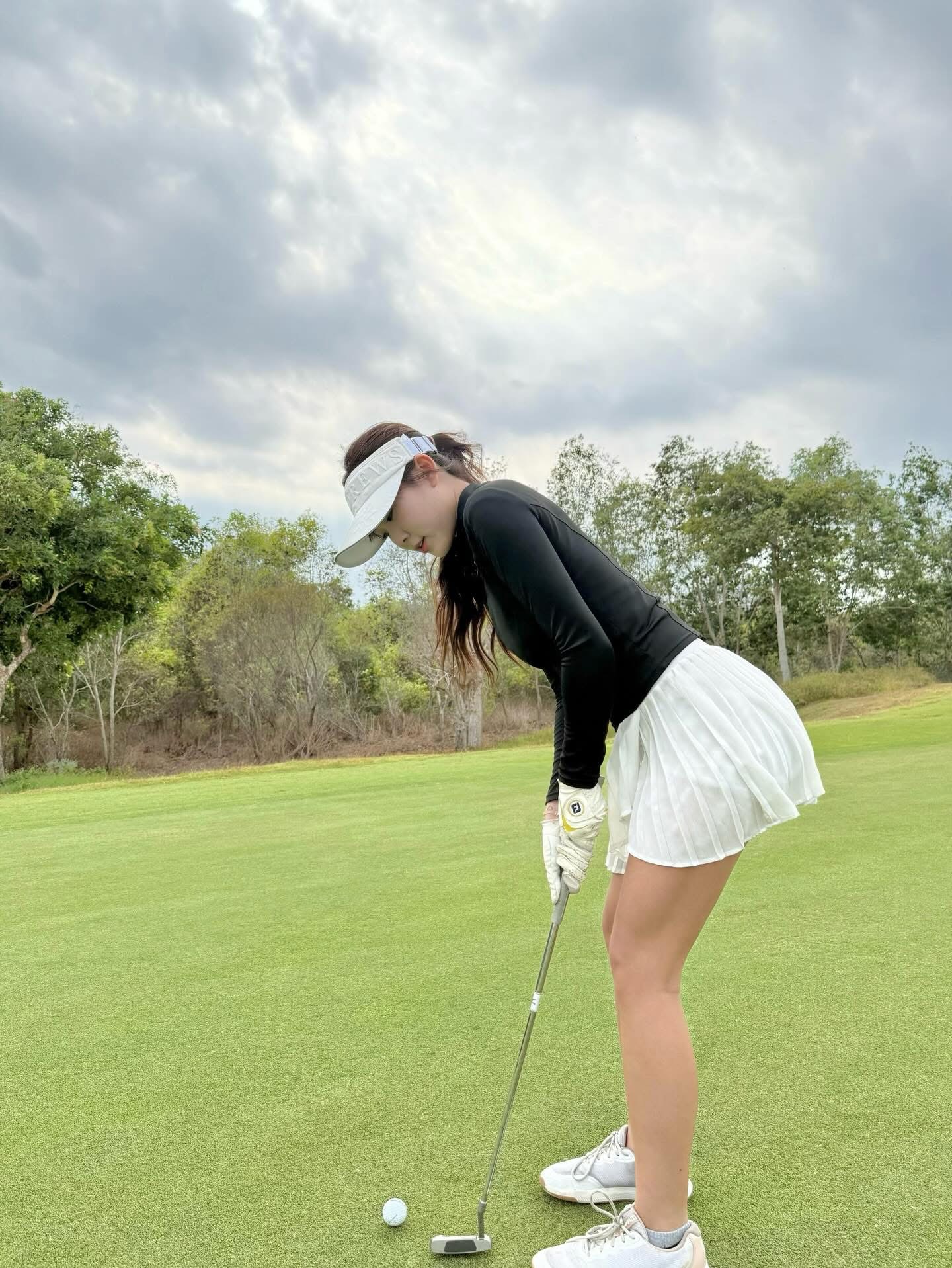 Nàng Kim posing with golf club