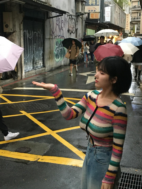 An Arang crossing street in rain