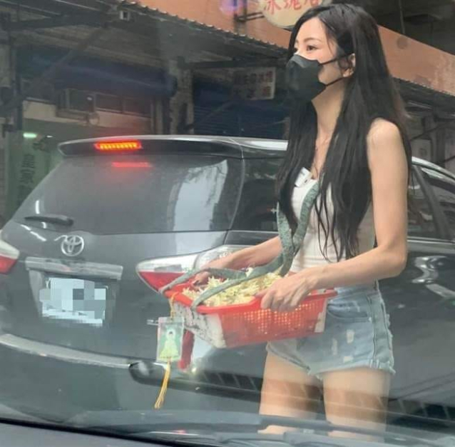 Young woman selling flowers on the street wearing a mask and shorts