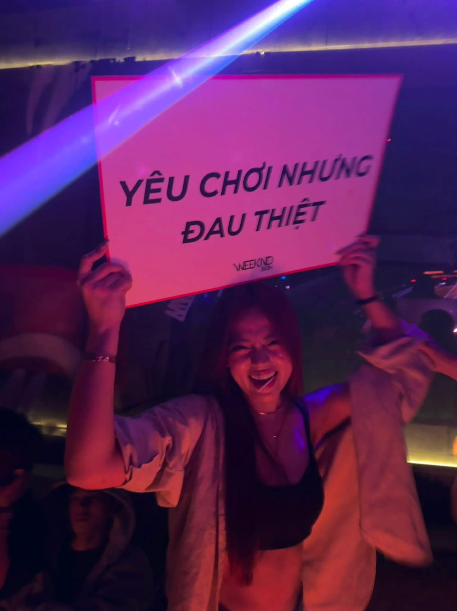 Helia Bảo Hân holding a sign that says 'Love for fun but it really hurts'