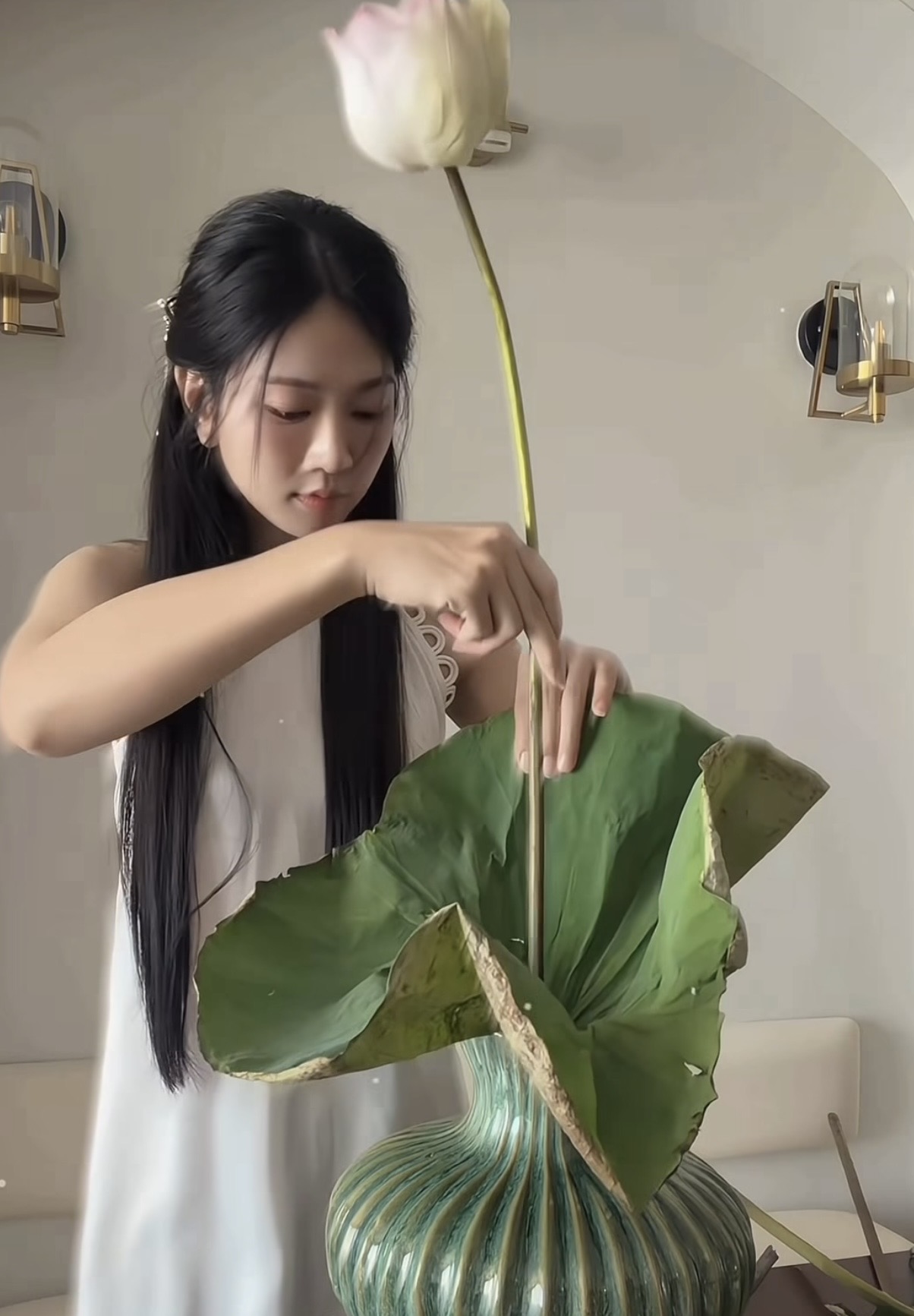 Le Bong in white silk dress with lotus flowers