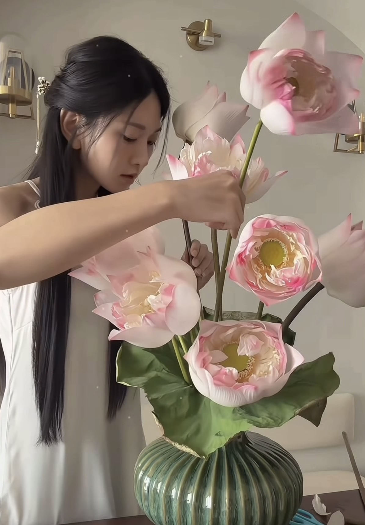Le Bong holding cat next to lotus flowers